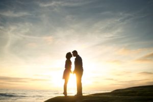 couple kissing in front of sunset