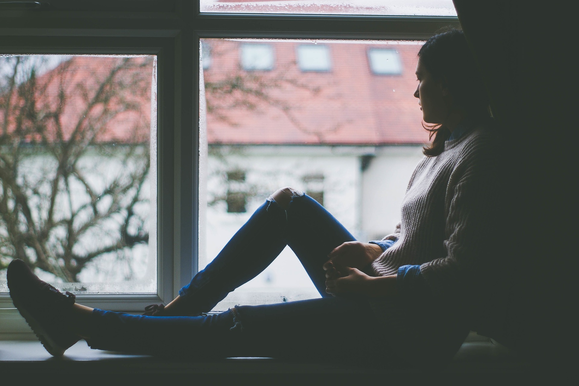 woman sitting in window looking out