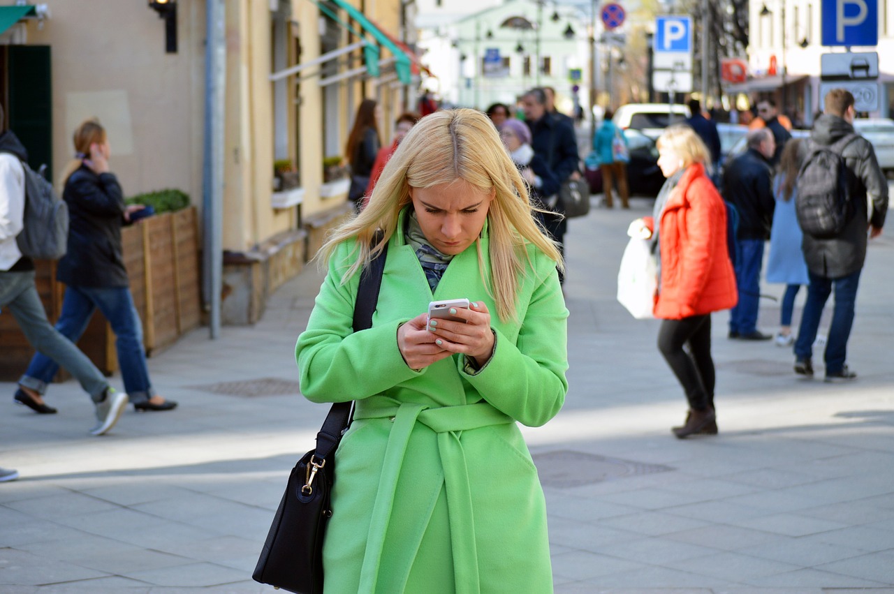 woman in coat looking at phone