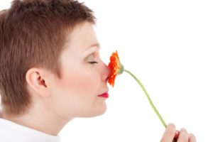 woman smelling red flower