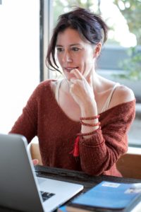 woman in sweater looking at computer
