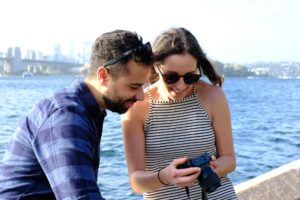 happy couple on a pier looking at a camera