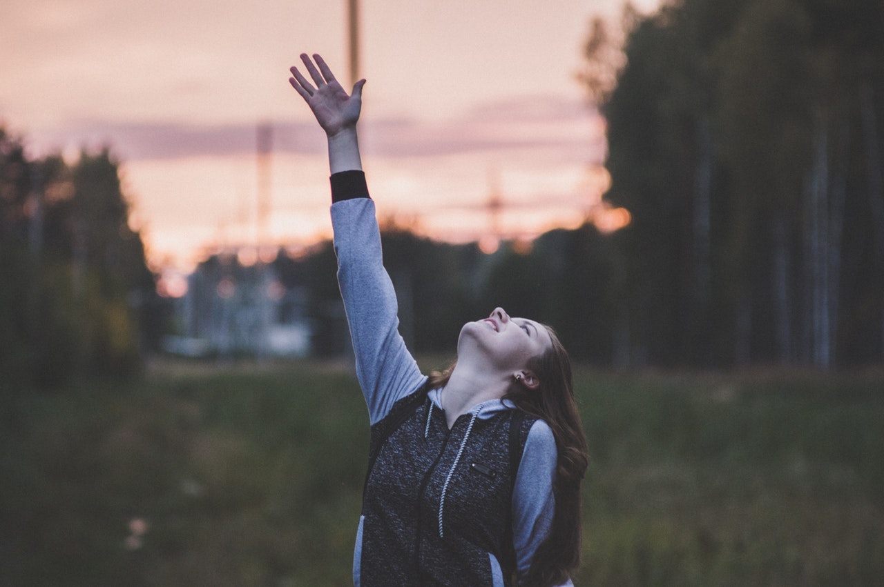 woman reaching up to the sky